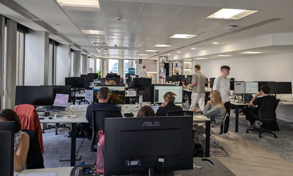 office with employees working on computers at desks