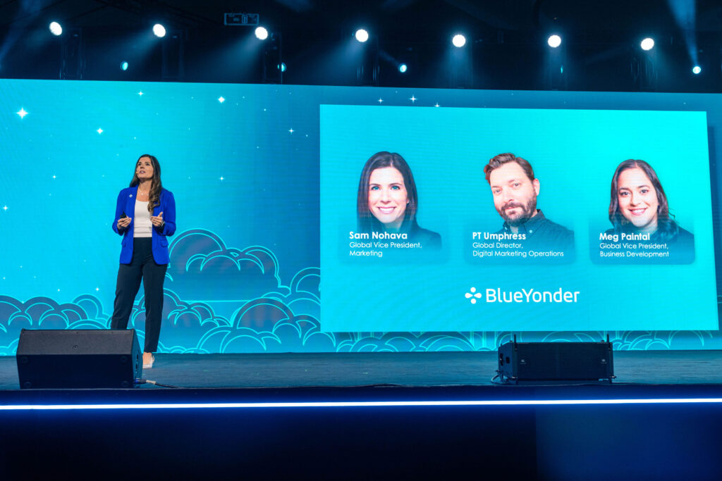 woman at conference speaking on a stage