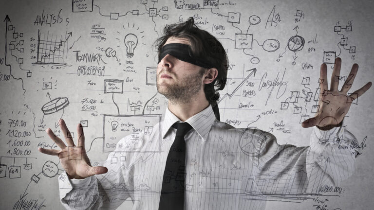 Blindfolded businessman navigating through complex business diagrams, charts and analytics, symbolizing intuitive decision-making amid data complexity